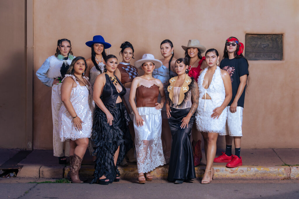 A large group of models are showing off their clothing designed by Kehala Smith.