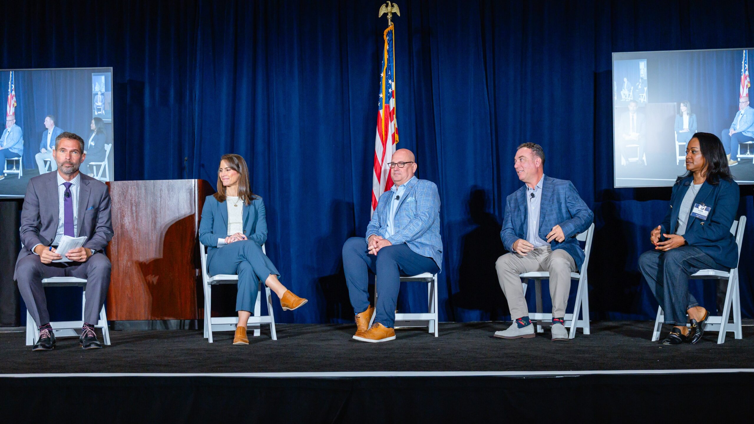 five people sit onstage