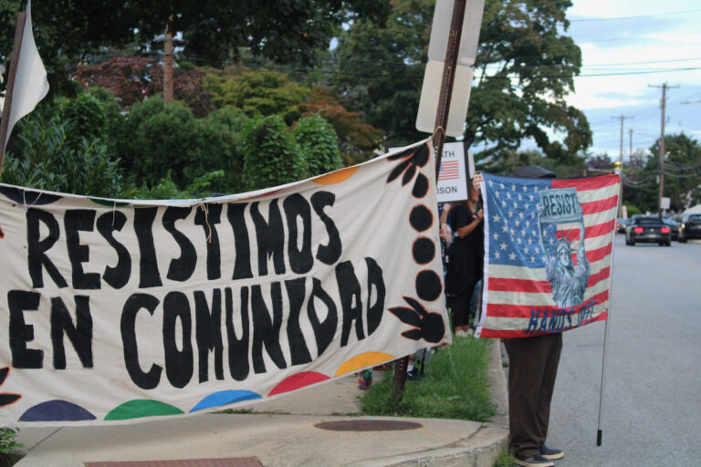 Several people are shown holding up handmade signs while standing on the side of the road for the anti-ICE protest in Norristown.