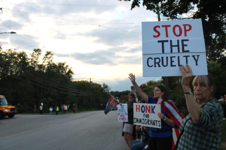 Several people are shown holding up handmade signs while standing on the side of the road for the anti-ICE protest in Norristown.
