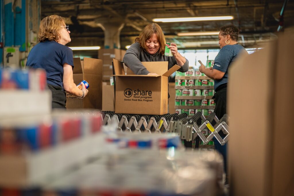SHARE food program volunteers pack boxes