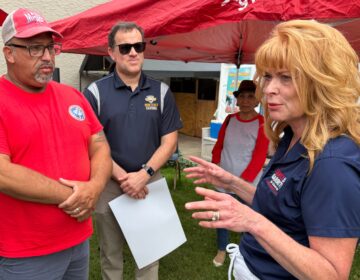 Stacy Garrity speaks with two people in Philadelphia while campaigning for the 2026 Pennsylvania governor's race